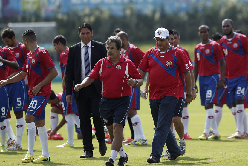 Presiden Kosta Rika, Luis Guillermo Solis (kanan), berjalan bersama pelatih timnas Jorge Luin Pinto dan pemain timnas di San Antonio de Belen, San Jose, Jumat (30/5). 