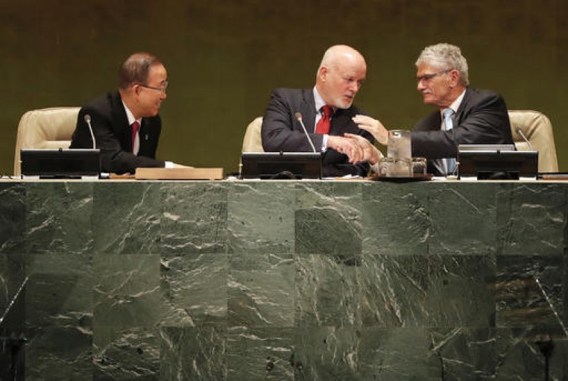 Presiden Majelis Umum sesi ke-71 PBB Peter Thomson (tengah) bersalaman dengan Presiden majelis Umum sesi ke-70 Mogens Lykketoft. Tampak Sekjen PBB Ban Ki-moon di kiri saat pembukaan KTT Pengungsi dan Migran, Senin (19/9) di markas PBB.