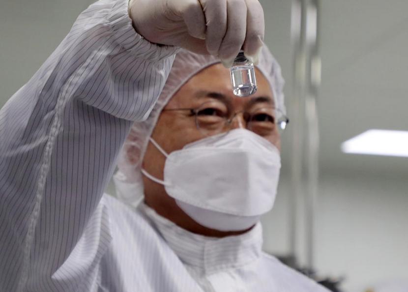 Presiden Korsel Terima Vaksin AstraZeneca. Presiden Moon Jae-in memegang botol vaksin Covid-19 saat kunjungannya ke pabrik SK Bioscience Co di tenggara Andong, Korea Selatan, 20 Januari 2021.