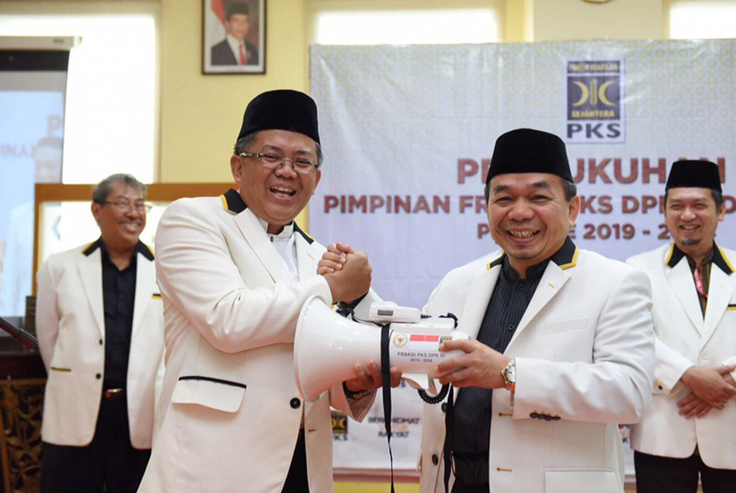 Presiden Partai Keadilan Sejahtera (PKS), Mohamad Sohibul Iman serahkan megafon dan pulpen kepada ketua Fraksi PKS di DPR RI dan MPR RI di Aula Gedung DPP PKS, Jakarta Selatan, Senin (30/10/2019).