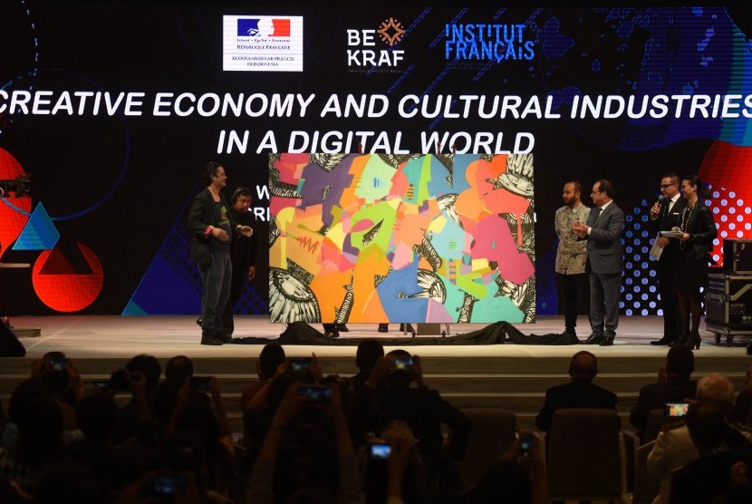 Presiden Perancis Francois Hollande (ketiga kanan) memperhatikan lukisan karya seniman asal Indonesia dan Perancis dalam Pertemuan Ekonomi Kreatif dan Promosi Industri Kebudayaan di Era Digital di Jakarta, Rabu (29/3).