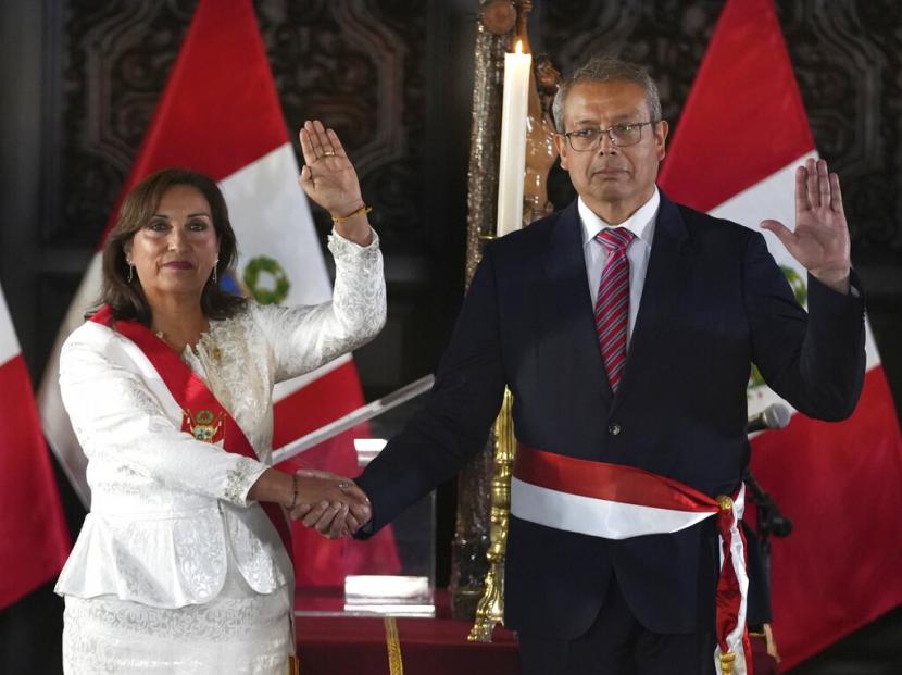  Presiden Peru Dina Boluarte dan Kepala Staf yang baru diangkat Pedro Angulo mengangkat tangan kanan mereka saat upacara pelantikan anggota kabinetnya, di istana pemerintah di Lima, Peru, Sabtu, 10 Desember 2022.