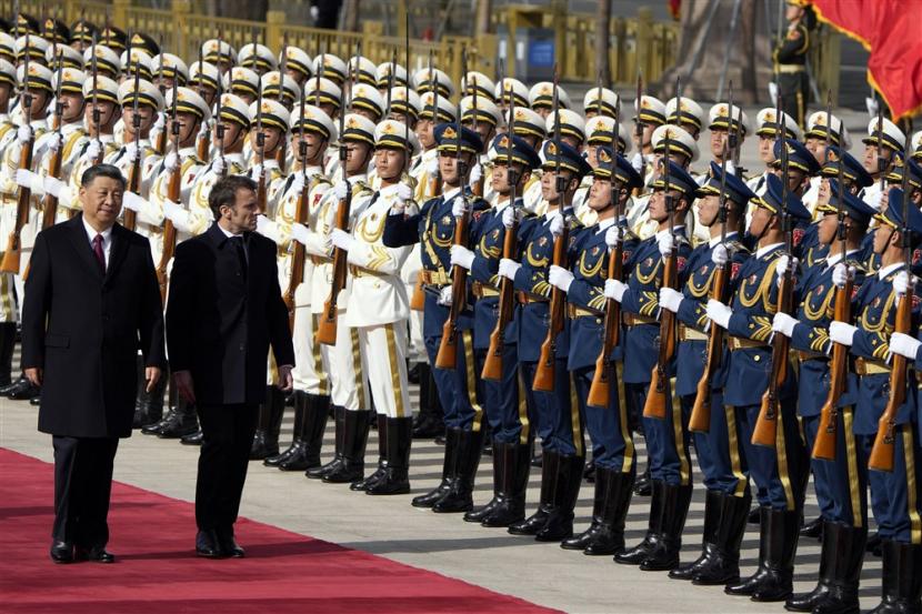  Presiden Prancis Emmanuel Macron (kanan) melintasi pasukan kehormatan bersama Presiden Cina Xi Jinping (L) di luar Great Hall of the People, Beijing, Cina, 6 April 2023.