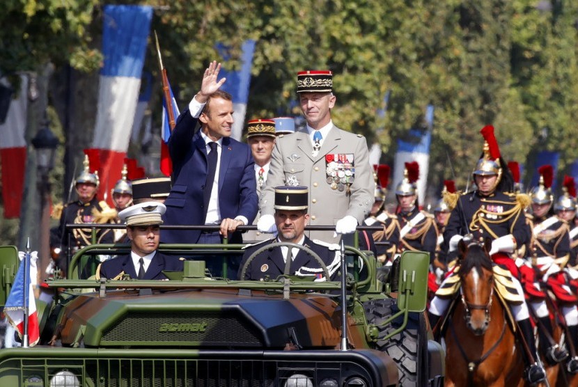 Presiden Prancis Emmanuel Macron (kiri) dan Kepala Staf Prtahanan Militer Prancis Jenderal Francois Lecointre meninjau tentara sebagai bagian dari parade Hari Bastille di Paris, Sabtu (14/7).