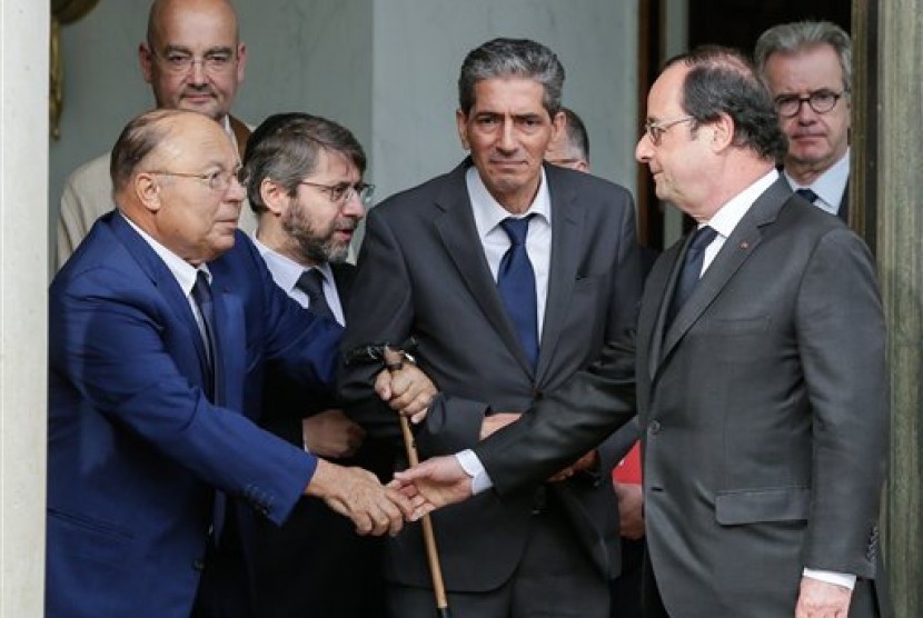 Presiden Prancis Francois Hollande berjabat tangan dengan Pemimpin Masjid Agung Paris Dalil Boubakeur (kiri).