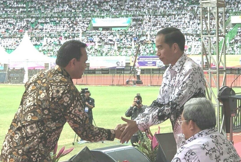 Presiden Republik Indonesia Joko Widodo (kanan) berkenan memberikan selamat kepada Direktur Human Capital Management Telkom Herdy R Harman. 