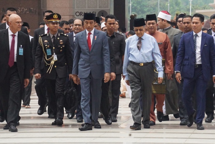 Presiden Republik Indonesia Joko Widodo (ketiga kiri) dan Perdana Menteri Malaysia Tun Dr Mahathir Mohamad (keempat kiri) berjalan bersama ke arah Masjid Putra Putrajaya, Malaysia, Jumat (9/8/2019) untuk melakukan salat Jumat bersama. 
