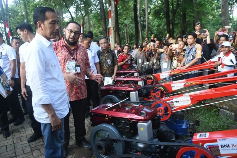Presiden RI Joko Widodo (Kiri) meninjau mesin traktor tangan yang merupakan bantuan Corporate Social Responsibility (CSR) dari PT Bank Negara Indonesia (Persero) Tbk (BNI) kepada para petani penggarap lahan di Sumatra Selatan.