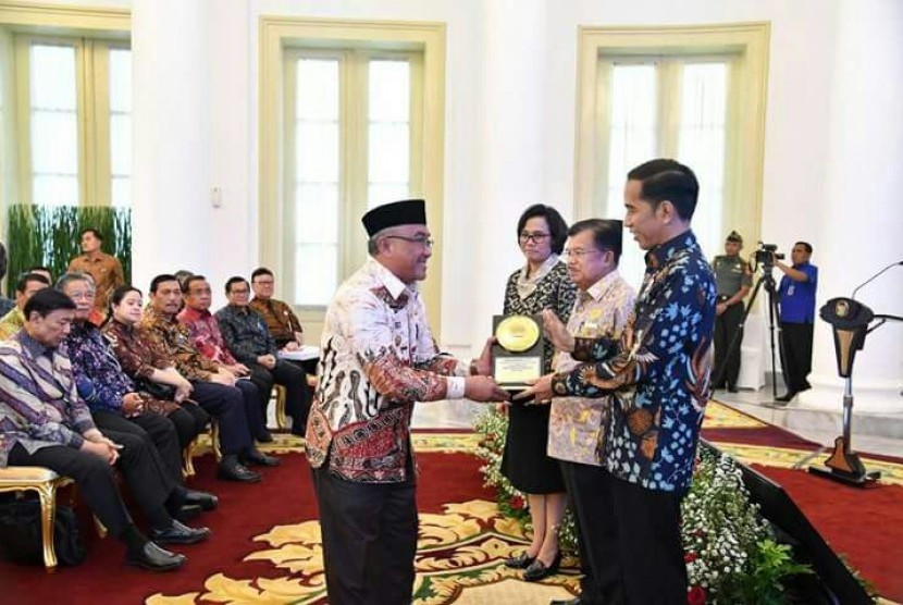 Presiden RI Joko Widodo menyerahkan penghargaan Anugerah Dana Rakca 2017 dari Kementerian Keuangan RI kepada Wali Kota Depok Mohammad Idris di Istana Bogor, Rabu (6/12).