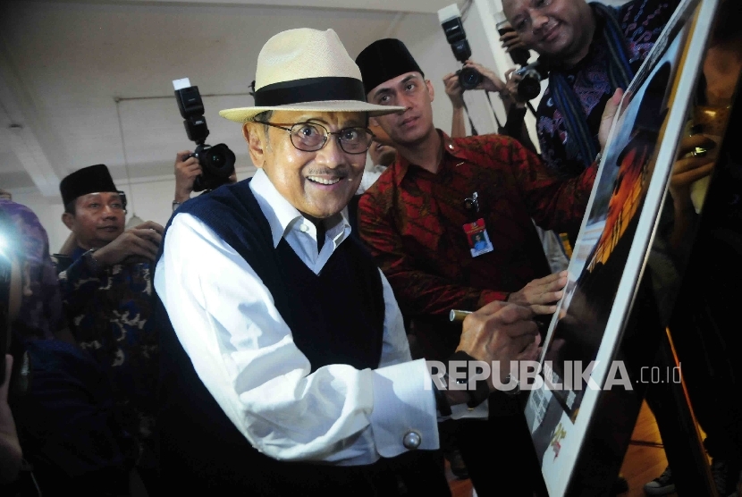   Presiden RI ke-tiga BJ Habibie menandatangai poster pameran foto Cinta Sang Inspirator Bangsa Kepada Negeri di Museum Bank Mandiri, Jakarta, Ahad (24/7). (Republika/Agung Supriyanto)