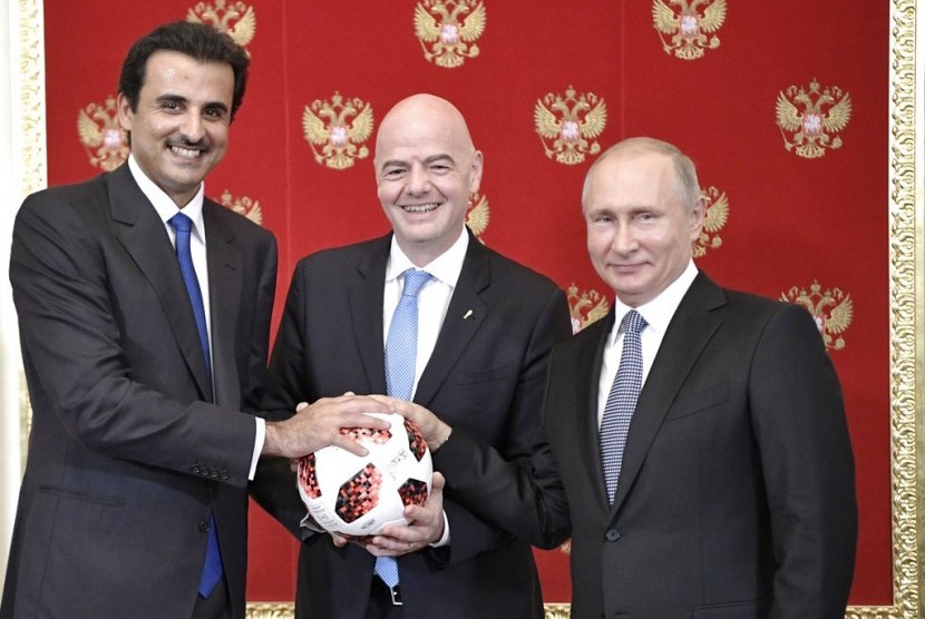Presiden Rusia Vladimir Putin (kanan), Presiden FIFA Gianni Infantino (tengah) dan Emir Qatar, Sheikh Tamim bin Hamad al-Thani berfoto dalam pertemuan di Kremlin, Moskow, Rusia, Ahad (15/7).