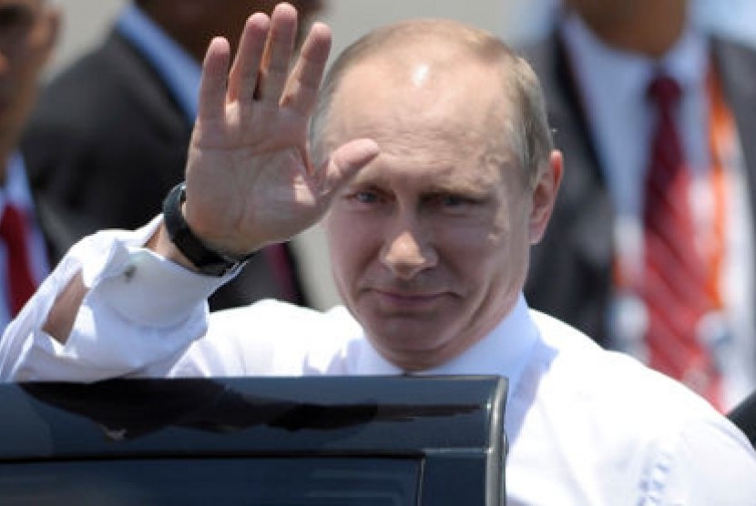 Presiden Rusia Vladimir Putin melambaikan tangan saat tiba di Bandara Ngurah Rai, Denpasar, Bali, Senin (7/10) untuk menghadiri KTT APEC 2013 di Nusa Dua.