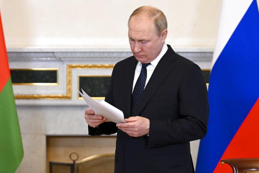 Presiden Rusia Vladimir Putin membaca makalah sambil menunggu pidato Presiden Belarusia Alexander Lukashenko di St. Petersburg, Rusia, Sabtu, 25 Juni 2022. Presiden Belarusia Beri Putin Kado Traktor