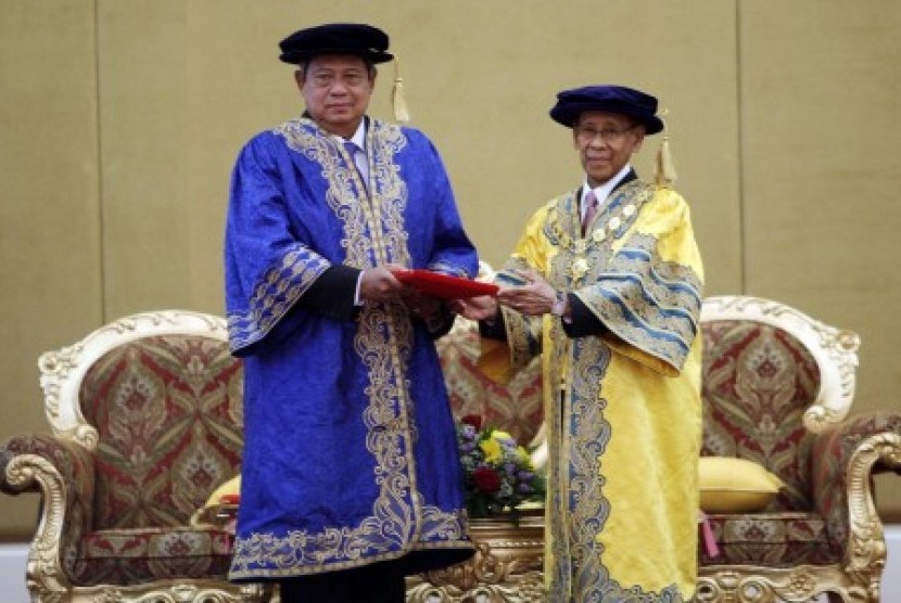 Presiden Susilo Bambang Yudhoyono (kiri) menerima gelar Doktor Honoris Causa (HC) atas kontribusinya untuk kepemimpinan dalam perdamaian dari Universitas Utara Malaysia (UUM) yang diberikan Yang Dipertuan Agong Abdul Halim Mu'adzam Shah (kanan) selaku Cons