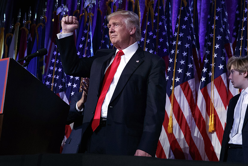 Presiden terpilih Donald Trump mengepal tinjunya selama malam kampanye pemilu di New York, Rabu  (9/11).