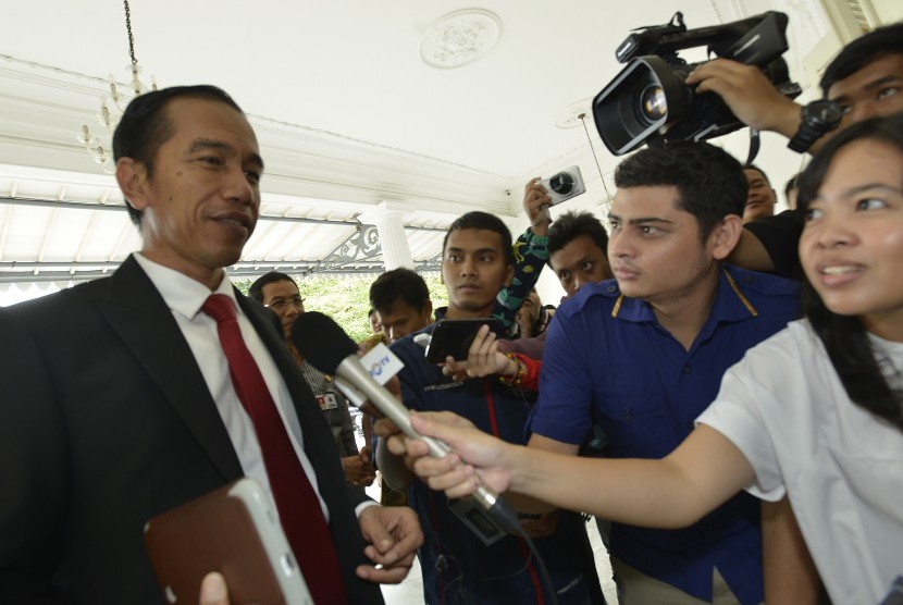 Presiden terpilih Joko Widodo (kiri) menjawab sejumlah pertanyaan wartawan ketika berjalan memasuki Balai Kota di Jakarta, Rabu (23/7). 