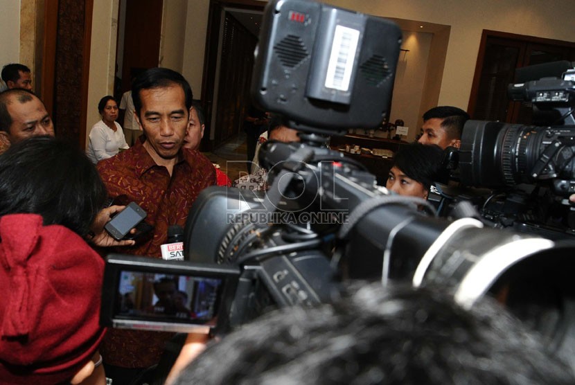   Presiden terpilih Joko Widodo menjawab pertanyaan media usai menghadiri forum silaturahmi Fraksi PDIP di Jakarta, Ahad (7/9).  (Republika/Tahta Aidilla)
