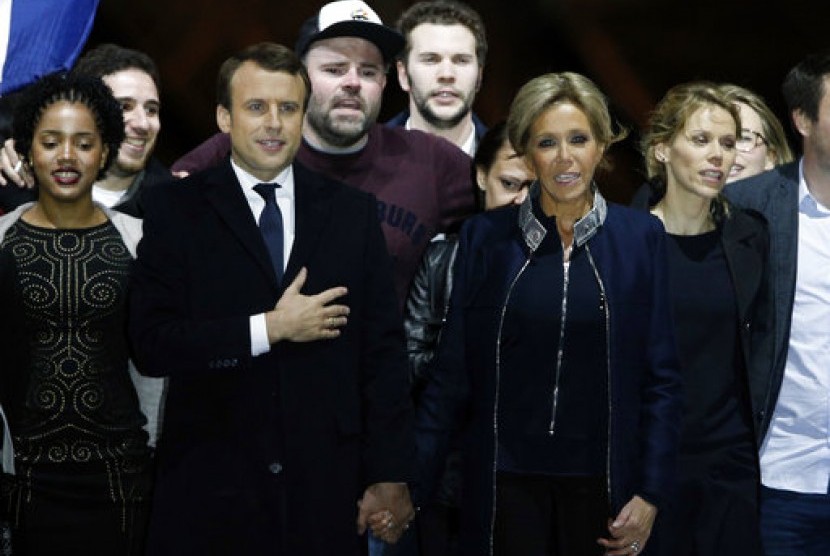Presiden terpilih Prancis Emmanuel Macron bergandengan tangan dengan istrinya Brigitte Trogneux saat merayakan kemenangan Macron di Museum Louvre, Paris, Ahad, 7 Mei 2017.