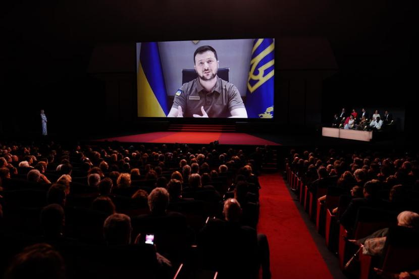 Presiden Ukraina Volodymyr Zelensky tampil dilayar dalam pembukaan Festival Film Cannes di Cannes, Prancis, 17 Mei 2022. Zelenskyy mengajukan kesepakatan resmi dengan negara-negara sekutu untuk mengamankan kompensasi Rusia atas kerusakan yang ditimbulkan pasukannya selama perang. 