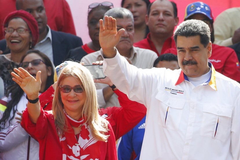 Presiden Venezuela Nicolas Maduro dan istri Cilia Flores melambaikan tangan kepada pendukungnya di luar istana kepresidenan Miraflores di Caracas, Venezuel, Senin (20/5). 