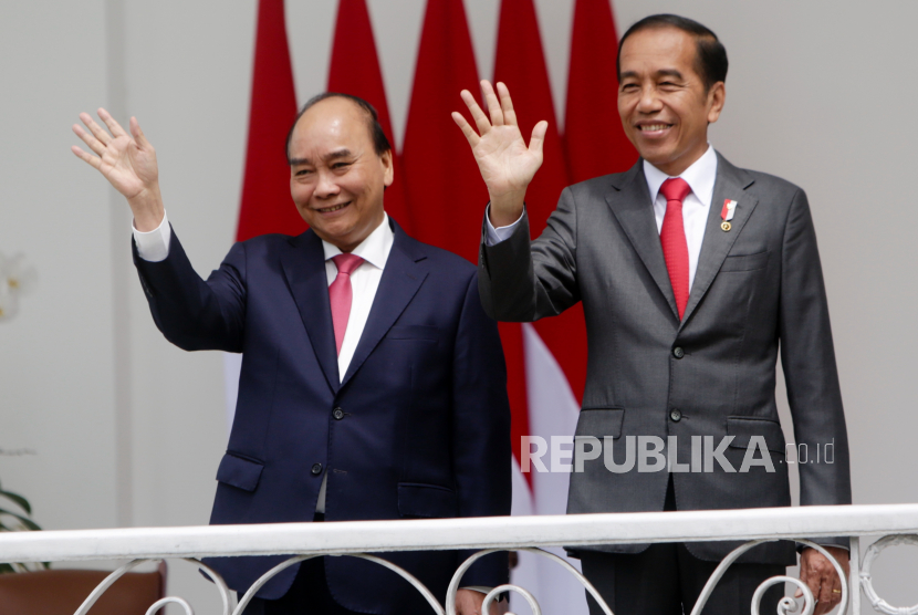 Presiden Vietnam Nguyen Xuan Phuc (kiri) dan Presiden Joko Widodo (kanan) melambaikan tangan kepada wartawan dalam pertemuan mereka di Istana Kepresidenan di Bogor, Kamis, 22 Desember 2022. Xuan Phuc mengunjungi Indonesia untuk membahas hubungan kedua negara.