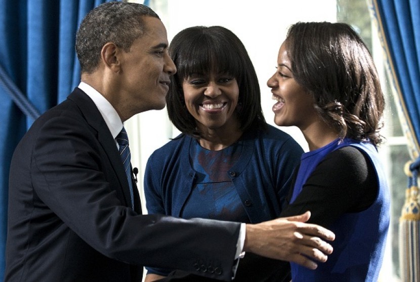 President Barack Obama embraces daughter Malia as first lady Michelle Obama watches after Obama was officially sworn-in by Chief Justice John Roberts, not pictured, in the Blue Room of the White House during the 57th Presidential Inauguration in Washington, Sunday, Jan. 20, 2013. 