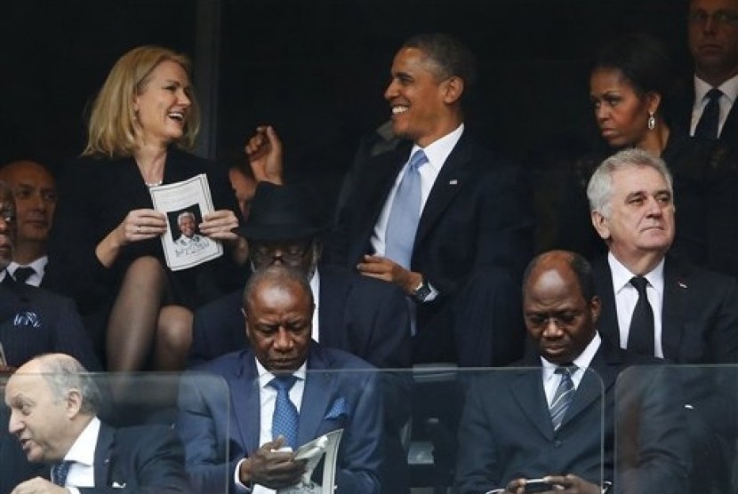 President Barack Obama (right) jokes with Danish prime minister, Helle Thorning-Schmidt as first lady Michelle Obama looks on at right during the memorial service for former South African president Nelson Mandela at the FNB Stadium in Soweto, near Johannes