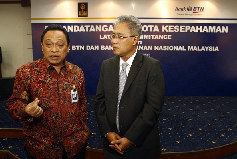 President director of Bank Tabungan Negara Maryono (left) talks with Datuk Adinan Maning, his counterpart from Malaysian's Bank Simpanan Nasional. Both sides secure agreement to develop remittance service, last week. (file photo)