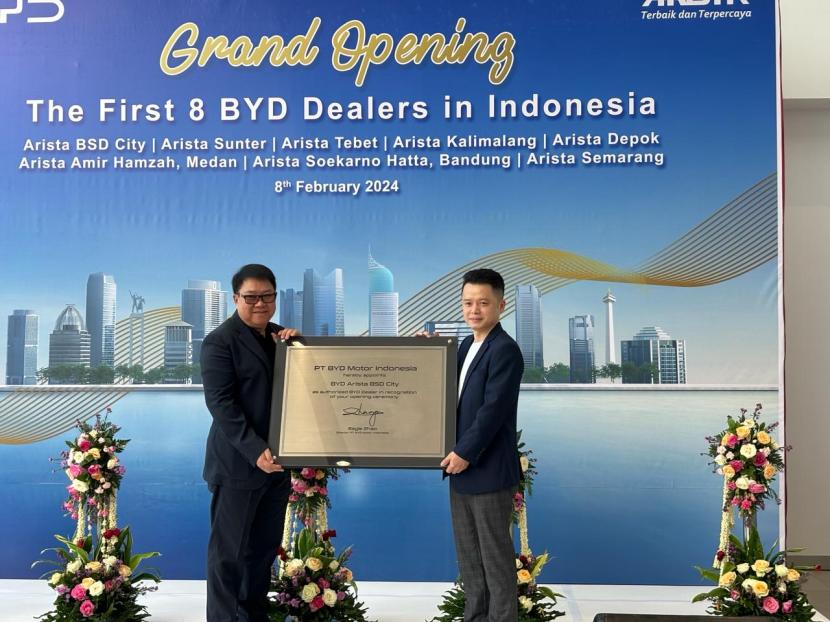 President Director PT BYD Motor Indonesia Eagle Zhao (kanan) memberikan plakat kepada Chairman Arista Group Hartono Sohor dalam peresmian delapan diler BYD yang dipusatkan di diler BYD Arista, Serpong, Tangerang, Kamis (8/2/2024).