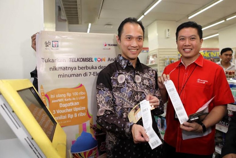 President Director PT Modern Putra Indonesia, Henri Honoris dan Vice President Postpaid Marketing, Derrick Heng, saat melakukan penukaran Telkomsel Poin di kiosk Sevelin, Jakarta, Senin (14/7).