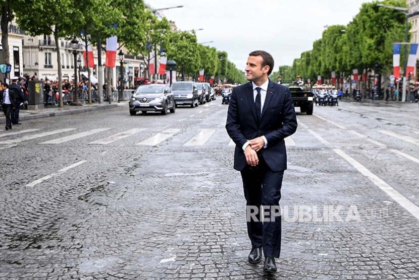 President Emmanuel Macron berjalan menuju Pusara pahlawan tak dikenal di Arc de Triomphe, Paris, Senin (15/5) dini hari.
