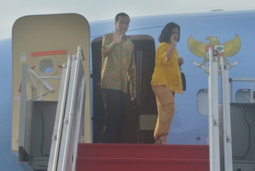President Joko Widodo (left) and Firs Lady Iriana wave  before departing to South Korea on Wednesday. 
