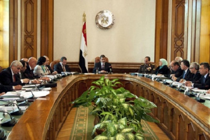 President Mohammed Morsi, center, meets with his cabinet including 10 new ministers after their swearing in at the presidential palace in Cairo, Egypt, Sunday Jan. 6, 2013.   