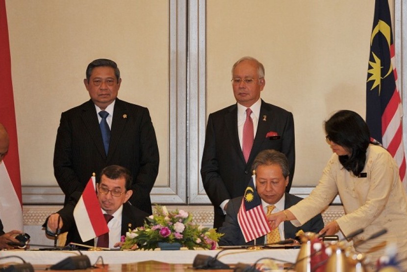 President Susilo Bambang Yudhoyono (left) and Malaysia's Prime Minister Najib Tun Razak witness the signing ceremony between Indonesian Minister of Social affairs Salim Segaf al Jufri (front left) and his counterpart, Anifah Aman, on Tuesday in Putrajaya, 