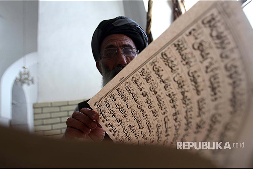 Pria Afghanistan membaca Alquran di Masjid Biru Kota Herat, Afghanistan, Jumat (18/5)