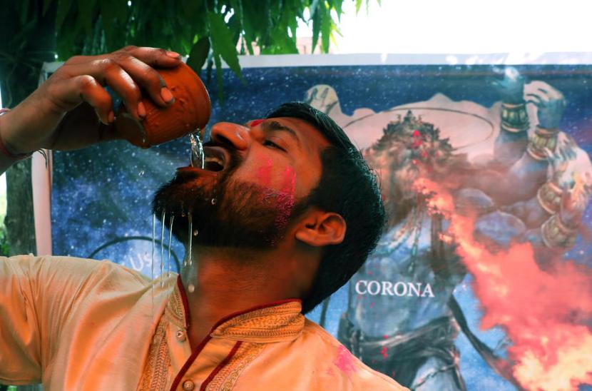  Pria di New Delhi, India, menenggak minuman dari urin sapi yang disebut bisa menangkal efek Covid-19.