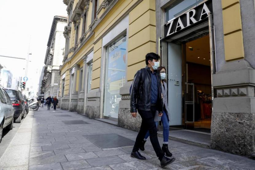 Pria melewati toko Zara yang ditutup akibat lockdown di Italia. Lockdown membuat penjualan daring merek Zara melonjak hingga 95 persen.