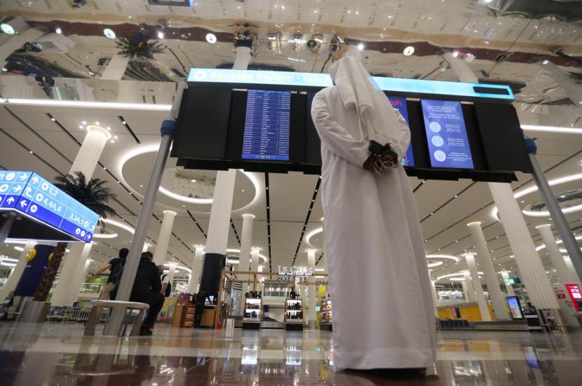 Pria melihat monitor penerbangan di Dubai International Airport. Kementerian Dalam Negeri Arab Saudi telah mencabut larangan masuk sebagai tindakan pencegahan terhadap varian virus corona jenis baru pada Ahad (3/1).