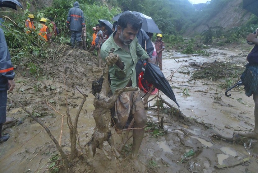 Pria membawa kambingnya sambil menyelamatkan diri dari tanah longsor di kawasan Bandarband, Bangladesh, (13/6).