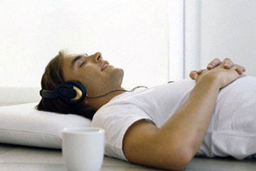 Pria mendengarkan musik melalui headphone