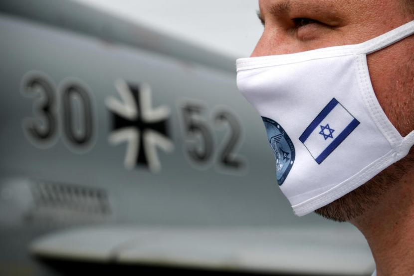 Pria mengenakan masker dengan gambar bendera Israel. MUI meminta ketegasan pemerintah agar bisa berkomitmen untuk tidak membuka hubungan diplomatik dengan Israel.