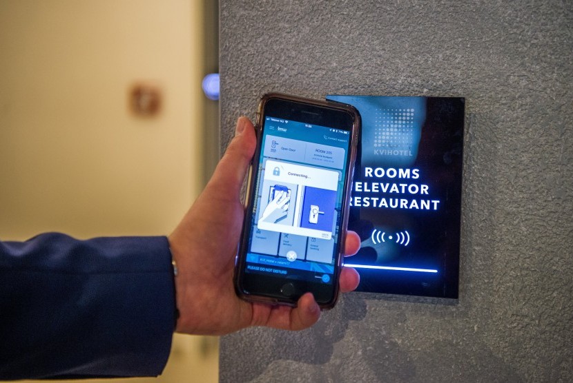 Pria menggunakan ponsel untuk masuk ke kamar hotelnya di KViHotel Budapest, Hongaria. Penggunakan teknologi dalam smart hotel menjadi daya tarik tersendiri bagi tamu. 
