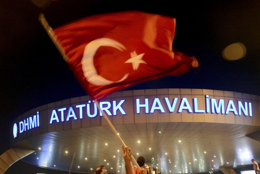 Pria mengibarkan bendera Turki saat upaya kudeta dilakukan terhadap pemerintah Turki beberapa waktu lalu.