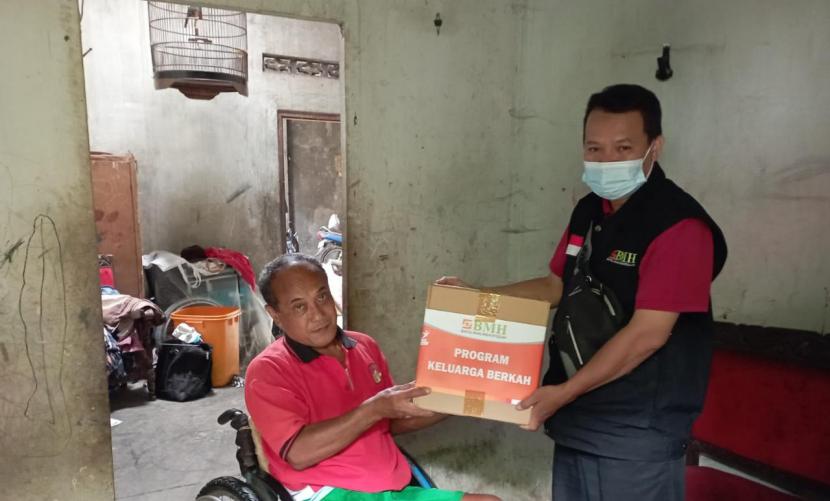 Prihatin (kiri),  warga Guyangan, Nogotirto, Godean, Sleman menerima bantuan sembako Program Keluarga Berkah yang disalurkan oleh Laznas BMH Perwakilan Yogyakarta.