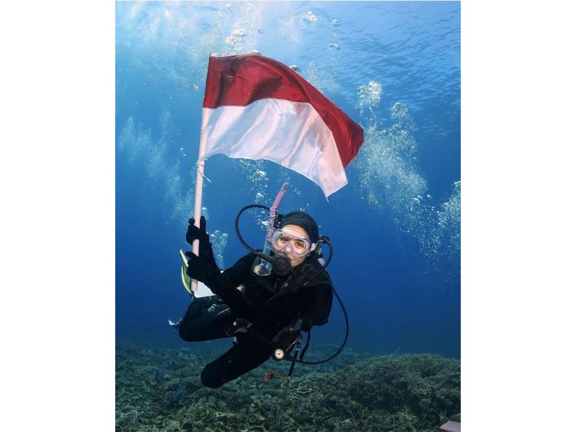 Prilly Laticonsina mengibarkan bendera merah putih di bawah laut untuk memeriahkan HUT ke-78 Republik Indonesia