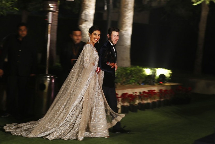 Priyanka Chopra dan Nick Jonas berpose untuk fotografer di resepsi pernikahan mereka di New Delhi, Selasa (4/12).