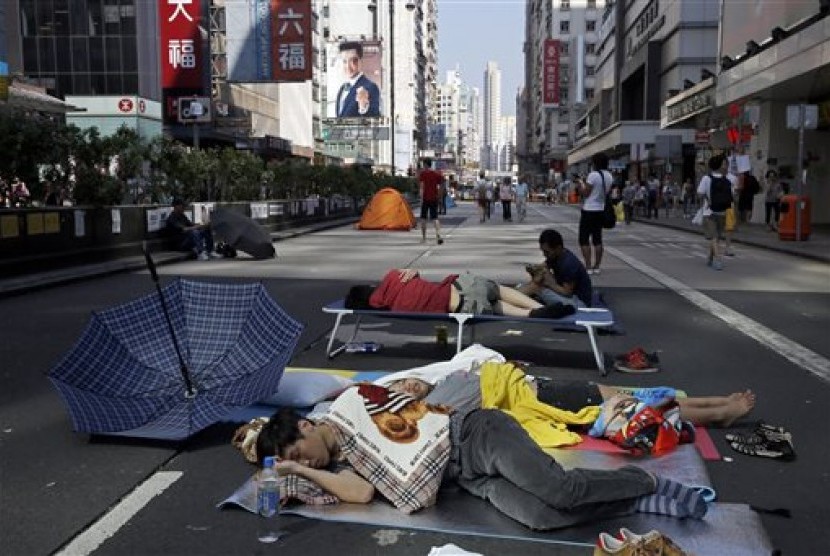 Pro-democracy protesters sleep in a main road in the occupied areas in Hong Kong's Mong Kok district Saturday, Oct. 11, 2014. 