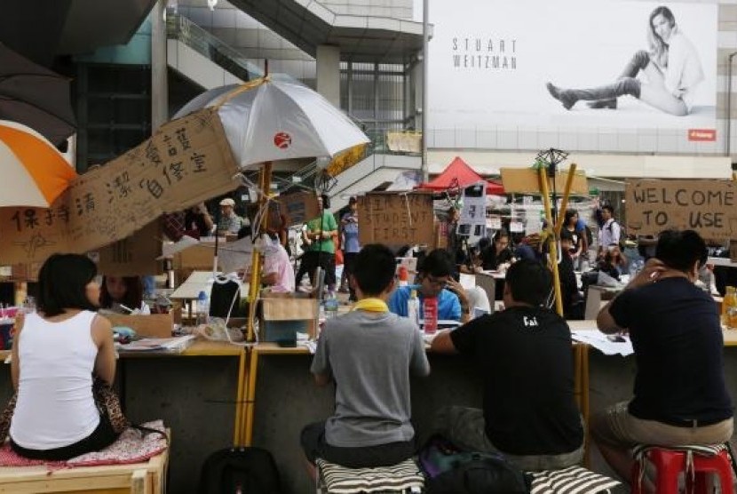 Pro-democracy students study on makeshift desks blocking a main road leading to the Central financial district in Hong Kong October 12, 2014.