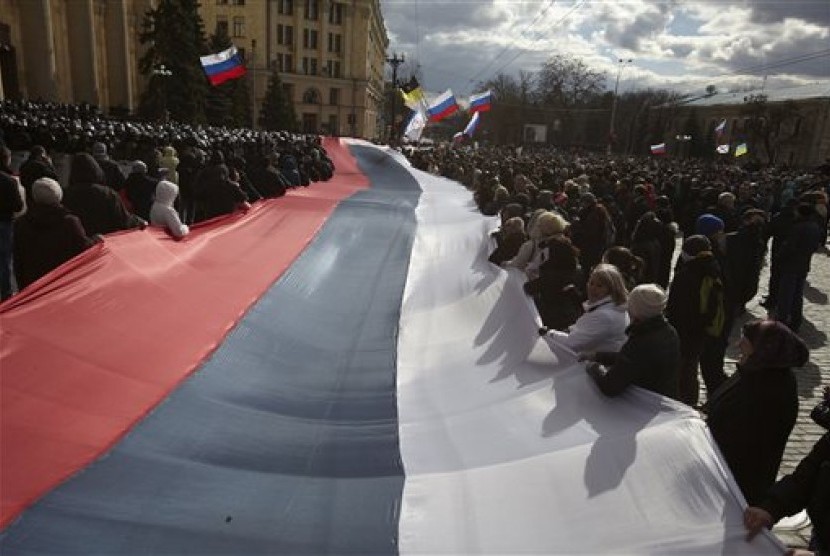 Pro-Russia demonstrators chant slogans as they carry a giant flag during a rally at a central square in Kharkiv, Ukraine, on Sunday March 16, 2014.