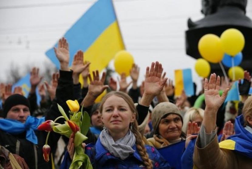 Pro-Ukrainian supporters raise their hands to symbolise a referendum and remember the victims of violence in recent protests in Kiev as they take part in a rally in Simferopol March 9, 2014.